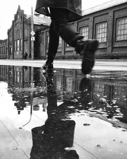 Low section of man with reflection in puddle