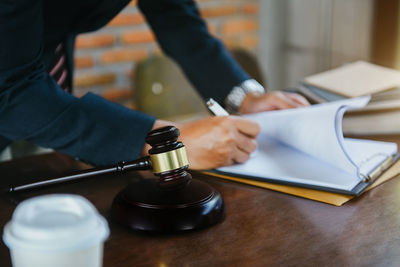 Midsection of lawyer working at table