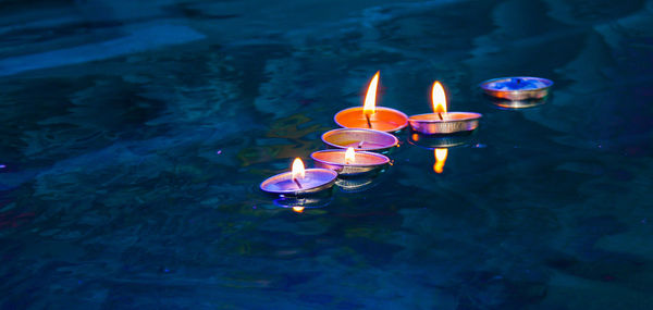 High angle view of lit candles in water