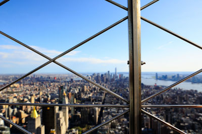 Cityscape seen through bridge against sky