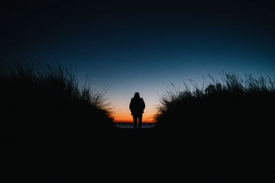 Silhouette woman standing against clear sky during sunset