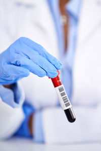 Midsection of scientist examining chemical in laboratory