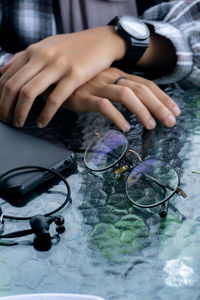 Close-up of hand holding eyeglasses on table