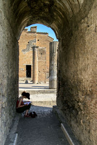 Woman sitting at archway