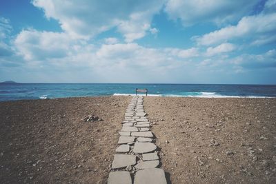 Scenic view of beach against cloudy sky