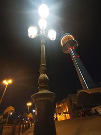Low angle view of illuminated street lights at night