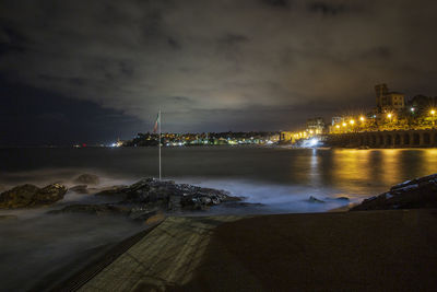 Scenic view of illuminated beach against sky at night