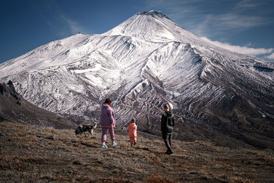 People on snowcapped mountain against sky