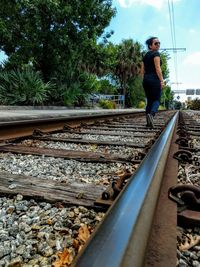 Man standing on railway tracks against trees