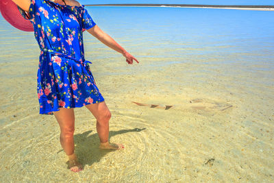 Low section of woman standing on beach