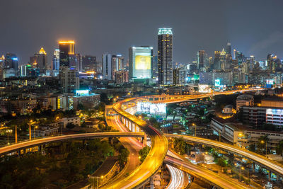 High angle view of illuminated street amidst buildings at night