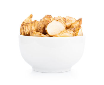 Close-up of bread in bowl against white background