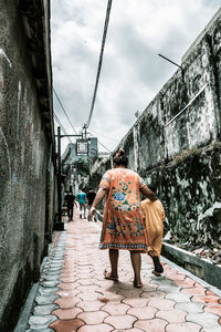 Rear view of women walking on footpath