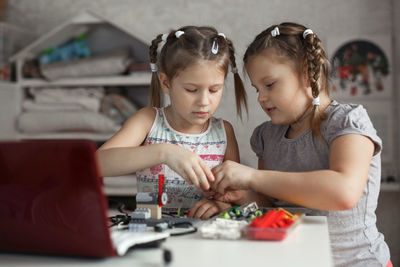 Portrait of cute girl playing with toy blocks at home