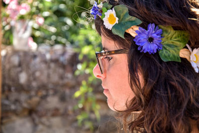 Close-up of thoughtful woman wearing flowers on head