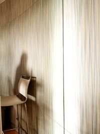 Empty chair against wall at home