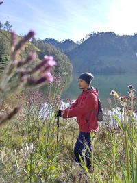 Side view of woman standing on field against mountain