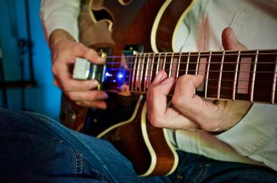 Man playing guitar at home