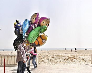 View of people on beach against clear sky