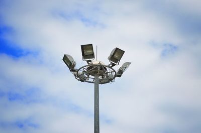 Low angle view of floodlight against cloudy sky