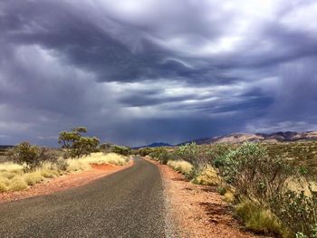 Country road against cloudy sky