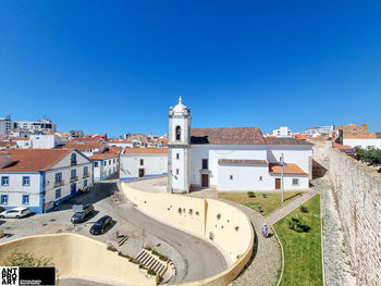 Buildings in city against clear blue sky