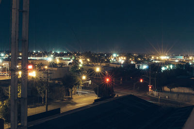 Illuminated cityscape against clear sky at night