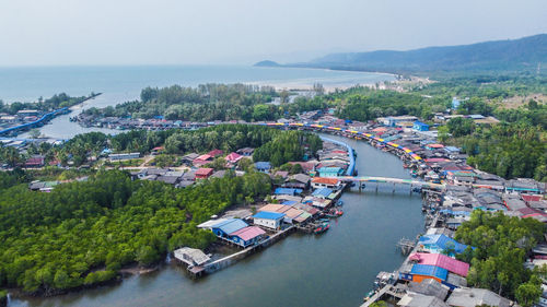 High angle view of city by sea against sky