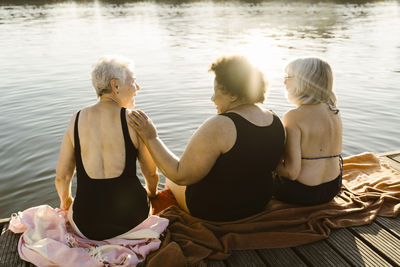 Rear view of woman sitting in water