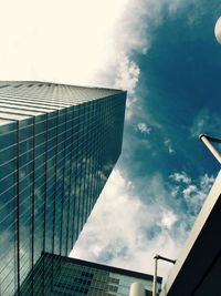 Low angle view of modern building against cloudy sky