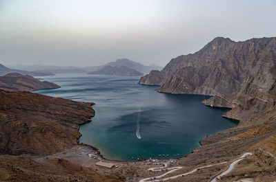 Scenic view of sea and mountains against clear sky