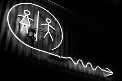 Low angle view of illuminated neon sign at night