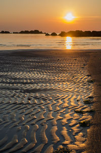 Scenic view of beach against sky during sunset