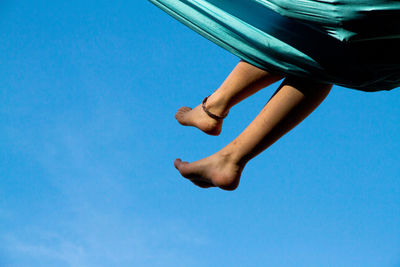 Low section of man against blue sky