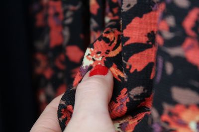 Close-up of hand holding leaf against blurred background