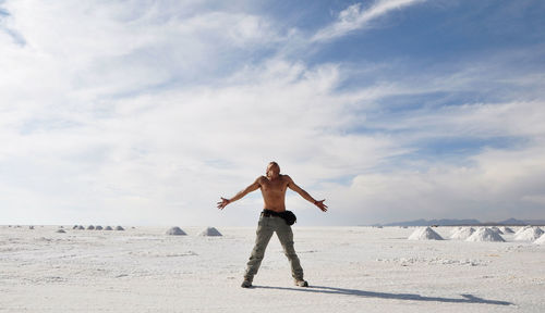 Full length of man standing on beach against sky