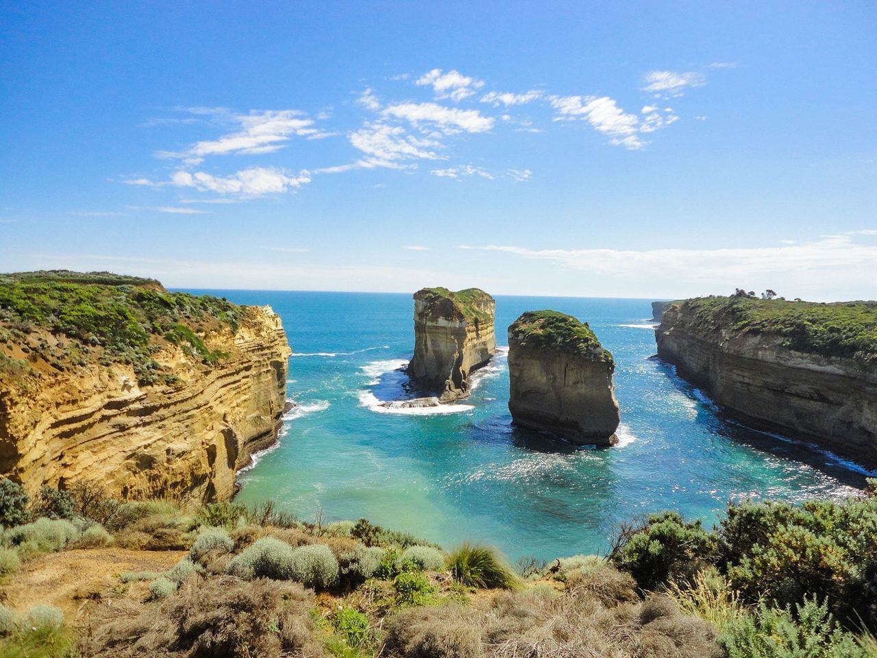 ROCK FORMATIONS IN SEA AGAINST BLUE SKY