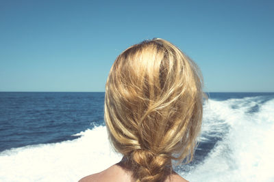 Rear view of woman looking at sea against clear sky