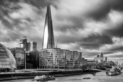 Modern buildings in city against cloudy sky