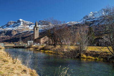 Scenic view of lake by snowcapped mountains against clear sky