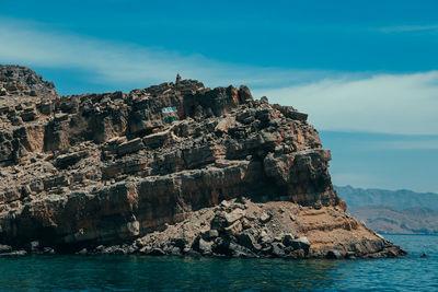 Rock formations by sea against sky