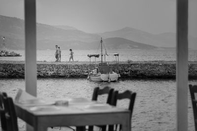 Boats moored at pier on sea