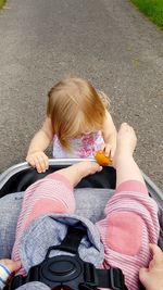 Low section of girl standing by baby in stroller