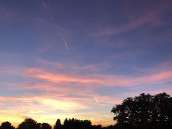 Low angle view of silhouette trees against sky at sunset