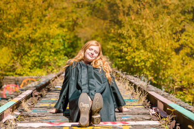 Portrait of woman standing on railroad track