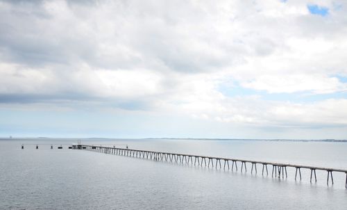 Wooden pier on sea against sky