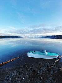 Boats moored in sea against blue sky