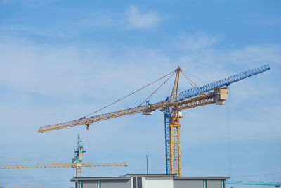 Low angle view of crane against sky