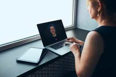 Businesswoman having business video call on laptop in office. woman remotely working from office