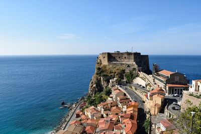 Aerial view of cityscape by sea against sky